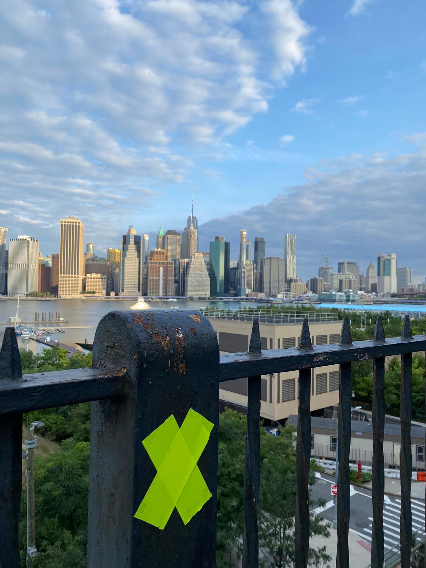 Gele absumo op ijzeren brugleuning, met op de achtergrond de skyline van NY
